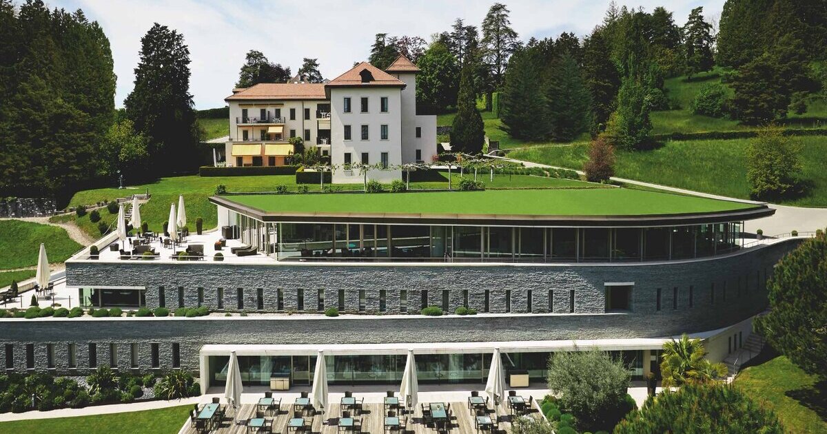 Clinique La Prairie aerial view — historic Château and modern spa building with green roof terrace, Montreux Switzerland