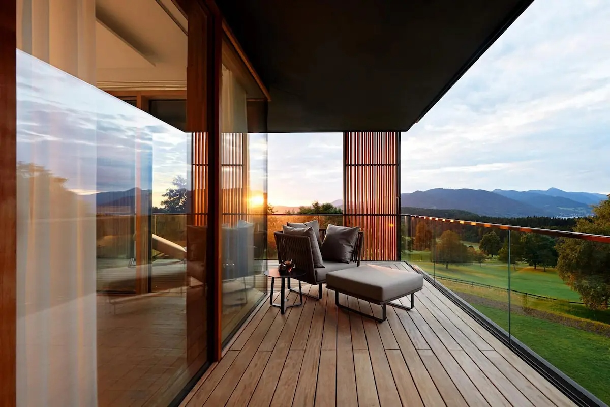 Lanserhof Tegernsee suite balcony at sunset — private terrace overlooking Bavarian Alps and golf course
