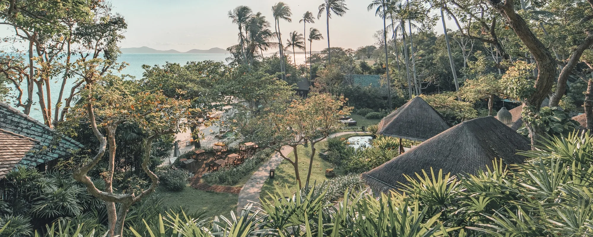 Aerial view of Kamalaya Koh Samui wellness sanctuary nestled among tropical jungle with private beach and ocean views